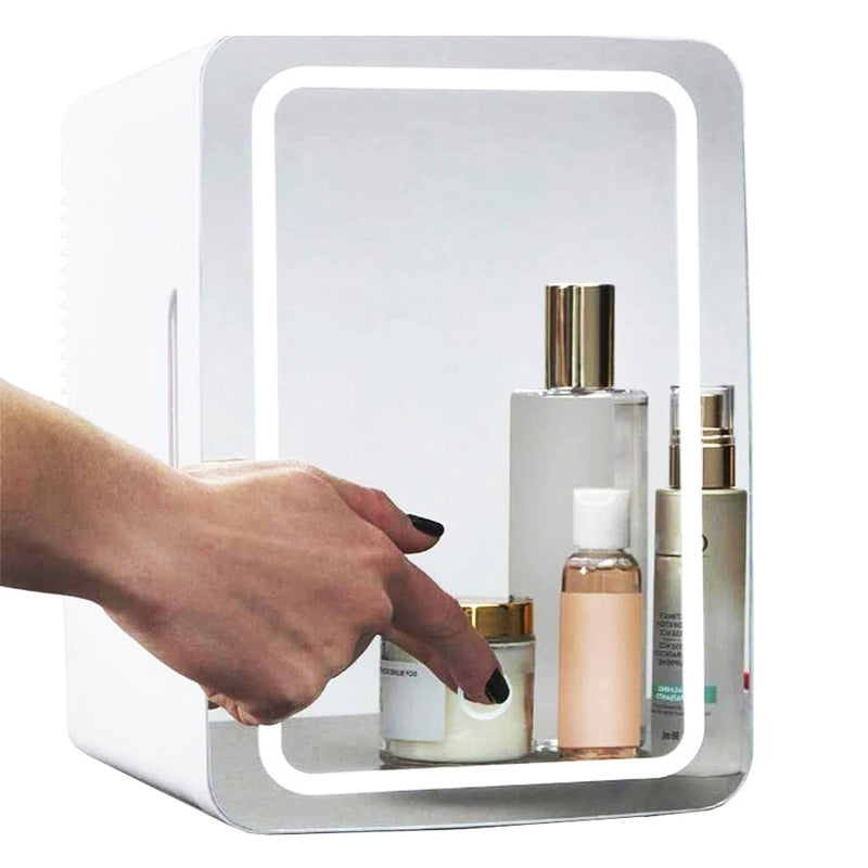 Hand reaching into a small refrigerator with skincare products inside on a white background
