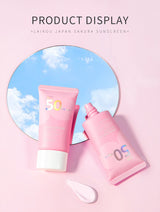 Two pink sunscreen bottles with a blue sky background on a pink background