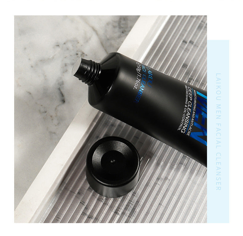 Black facial cleanser tube with blue text on a marble surface