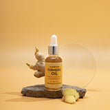 Bottle of turmeric oil with a dropper on a stone surface against a yellow background
